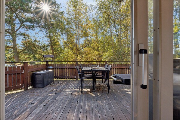 Eine Terrasse im Freien mit Tisch, Stühlen, einem Mülleimer und einer Bank.