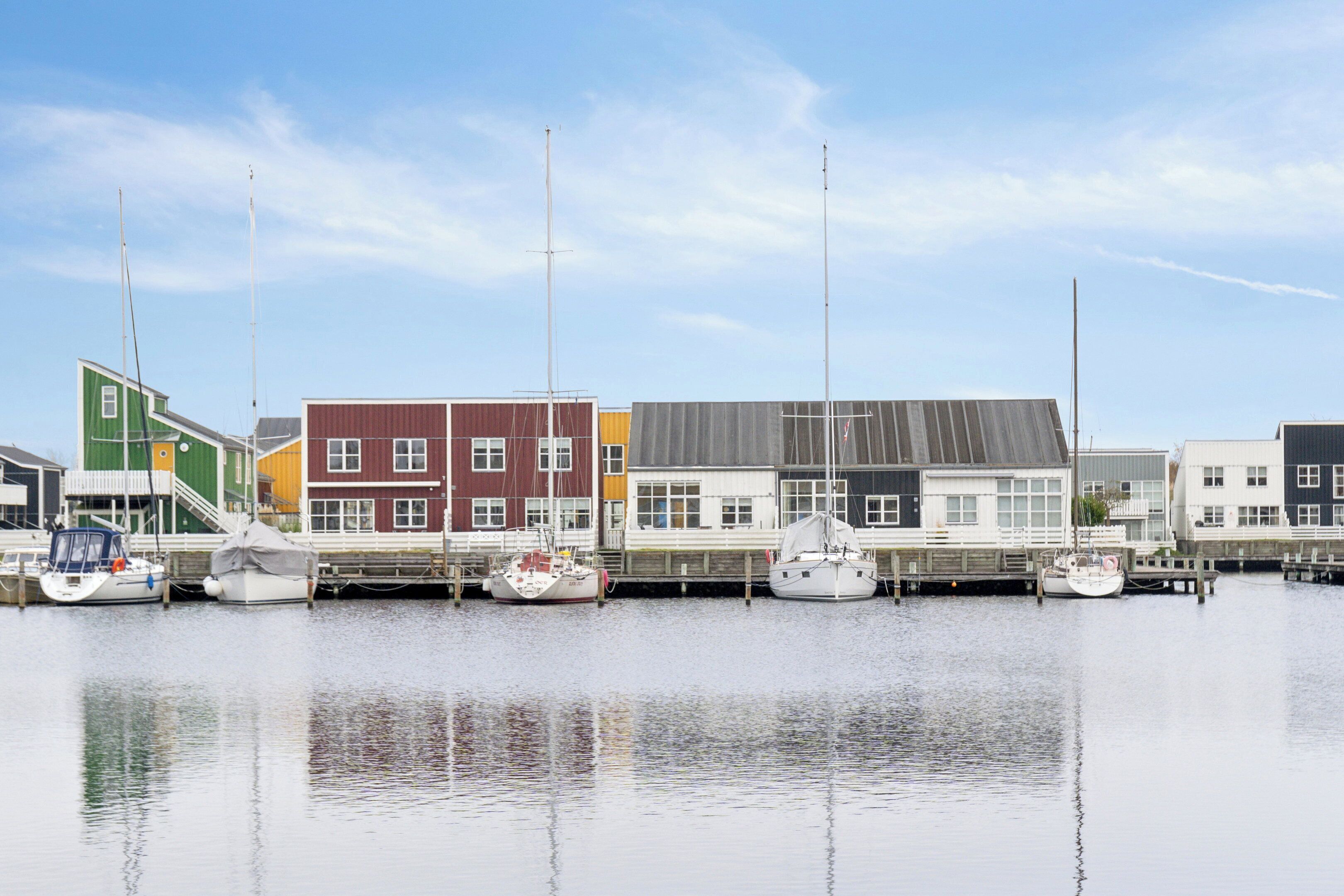 Un puerto deportivo con barcos amarrados y edificios coloridos al fondo.