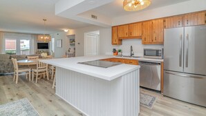 A modern kitchen with wooden cabinets, stainless steel appliances, and a central island. - Steps to Beach! Spacious 3bd with pool! Murrells Inlet! Family friendly (Murrells Inlet)