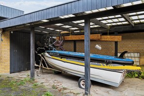A covered outdoor area with a boat and bicycle rack.