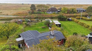 Una propiedad costera con varias casas, césped y vistas al mar.