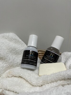 Een douche, handdoeken, zeep, shampoo