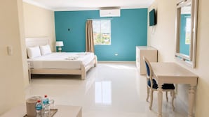 A hotel room with a bed, desk, chair, and a window with curtains. - Hotel El Imperio Punta Cana (Punta Cana)
