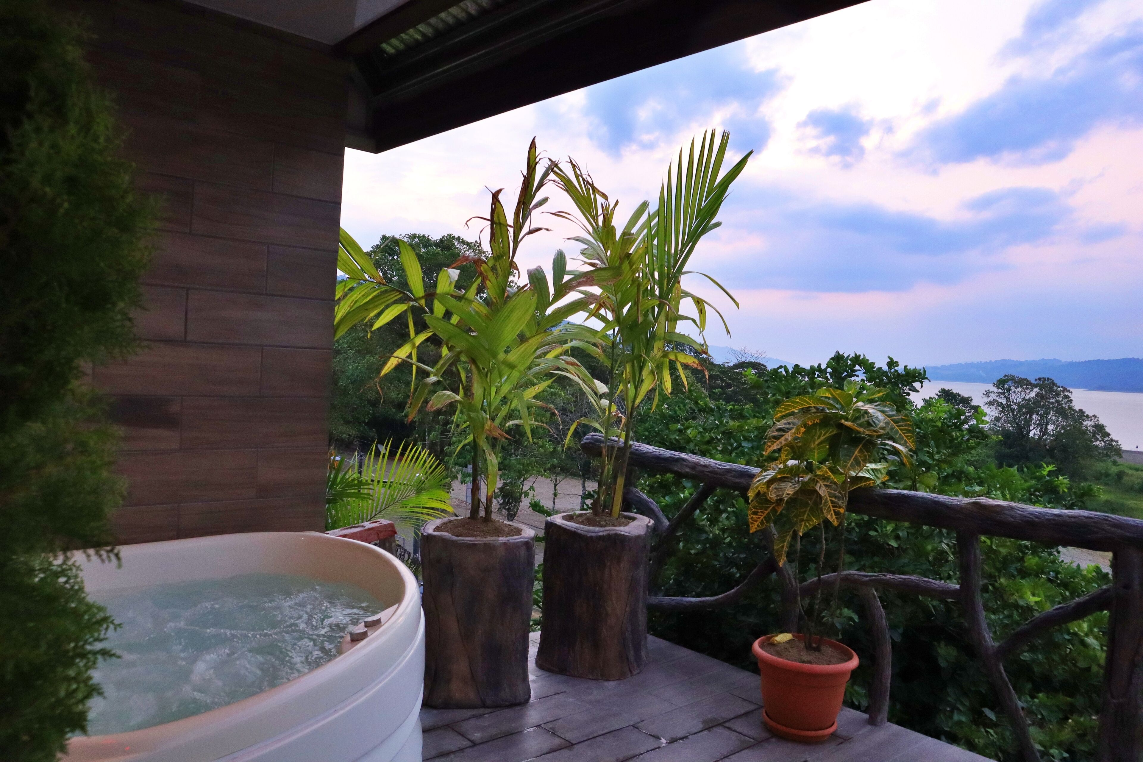 A wooden deck with potted plants and a hot tub.