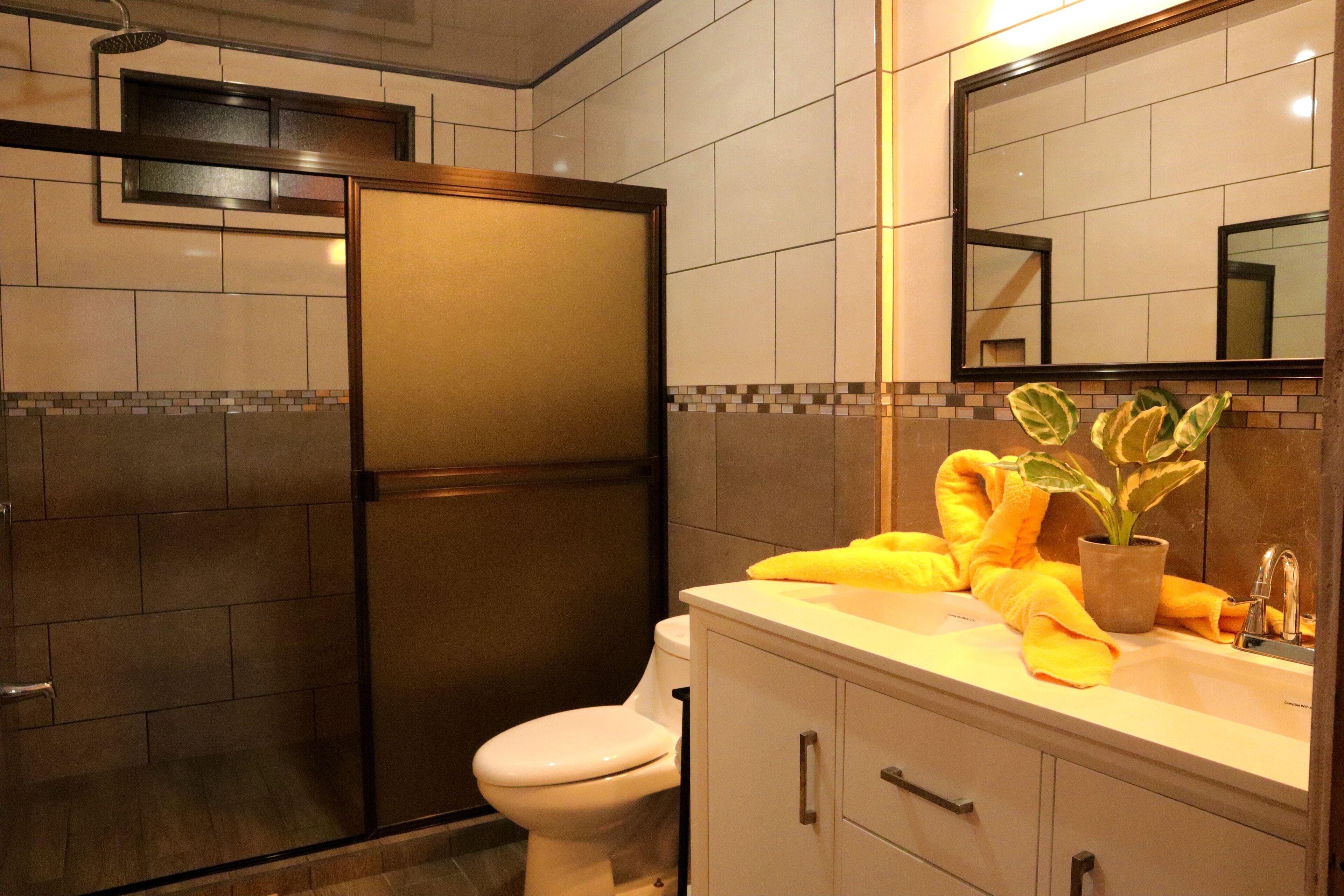 A modern bathroom with a shower, toilet, and vanity.