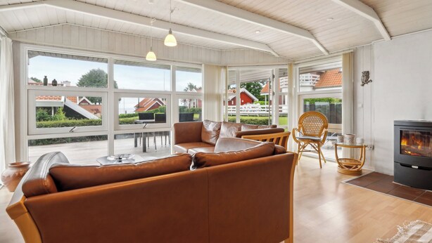 Een ruime woonkamer met een groot raam, een open haard en een gezellige zithoek.