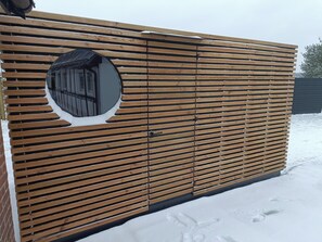 Una cerca de madera con listones horizontales y un ventanal circular.