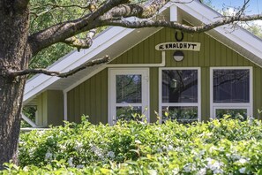A building with a sign reading 'REKNALDHYT,' surrounded by lush greenery.