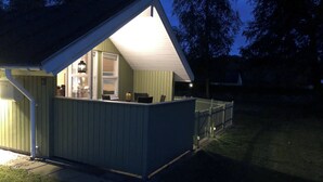 En liten, envåningsbyggnad med ett sluttande tak, en synlig dörr och en liten veranda.