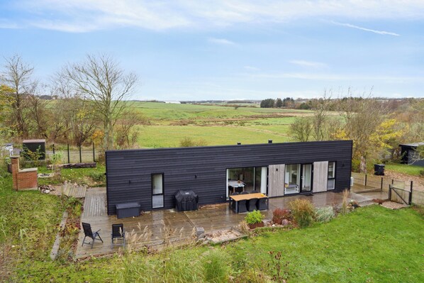 A modern house with a patio, a table, and chairs.
