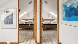 A room with a wooden ceiling, two beds, a framed abstract painting, and a white wall. - Lovely house with pool near charming Aarhus (Hasselager)
