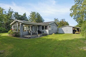 A single-story house with a porch, a garage, and a well-maintained lawn. - Lovely cottage with view of the Limfjord (Storvorde)