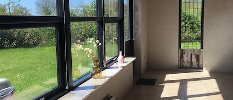 A room with large windows, a radiator, and a tiled floor.