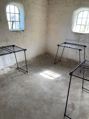 A room with three metal drying racks, two windows, and a concrete floor. - Idyllic country house with sea view and sunsets (Rønne)