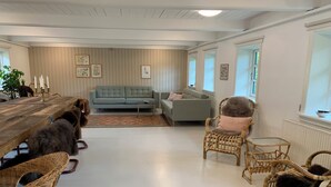 Un salon confortable avec un canapé, des fauteuils, une table basse et une table à manger.