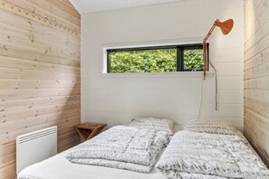 Ein Schlafzimmer mit einem Bett, einem Fenster und einer Heizung.