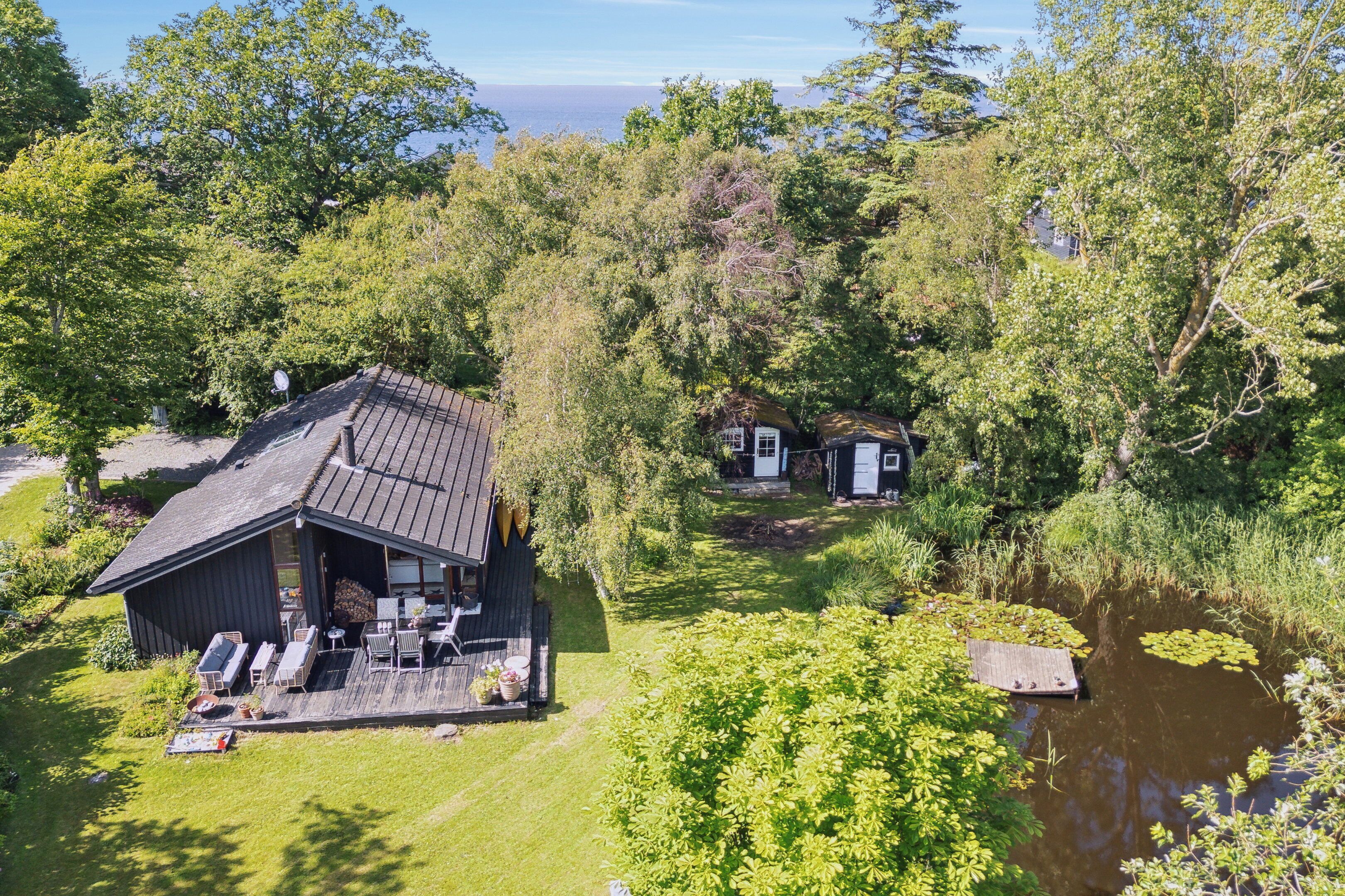 Et hus med terrasse, et spejløse og havudsigt.