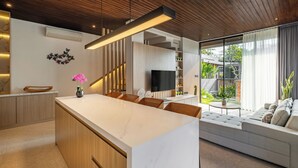 A modern kitchen with a large island, wooden cabinetry, and a built-in TV. - Private Villa Ayra 9A 10min MelastiBeach (Ungasan)