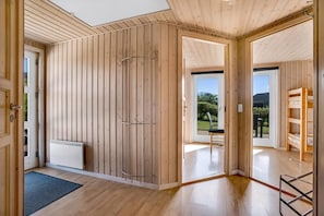 Interior moderno em madeira com uma grande porta deslizante dando para um jardim.
