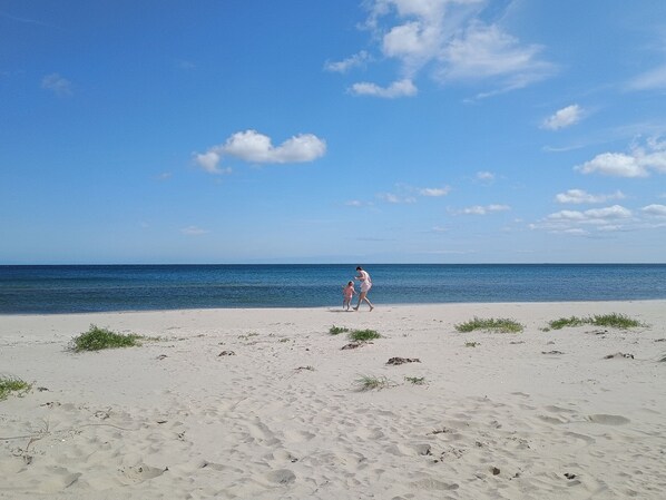 A beach with a clear sky and calm sea.