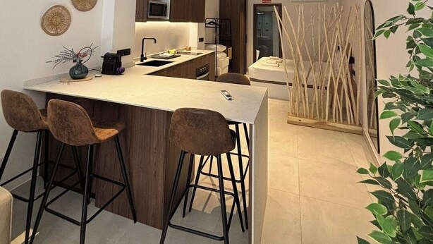 A modern kitchen with a central island, bar stools, and a dining area. - VLC HOST - Luz Casanova E (Valencia)