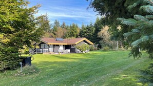 A house with a sloped roof, a patio with outdoor furniture, and a well-maintained lawn.