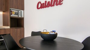 A conference table with a bowl and bottles, a wooden cabinet with a microwave, and a 'Cuisine' sign on the wall. - VLC HOST - Luz Casanova B (Valencia)