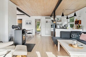 Ein modernes Interieur mit Kamin, Sofa, Essbereich und Küche.