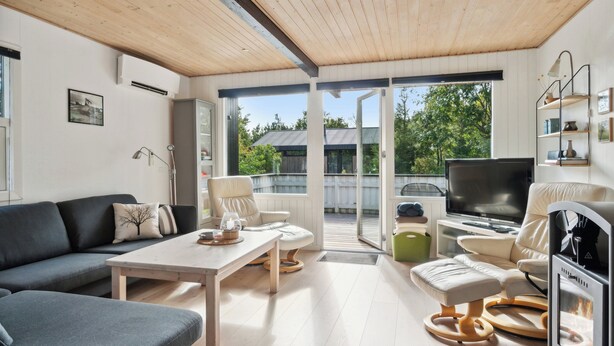 Una sala de estar moderna con sofá, mesa de centro, televisor y chimenea.
