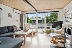 A modern living room with a sofa, coffee table, TV, and a fireplace.