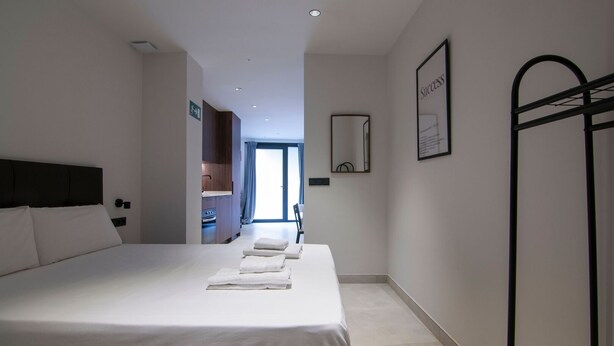 A modern hotel room with a large bed, a wardrobe, a mirror, and a view of the outside. - VLC HOST - Luz Casanova C (Valencia)