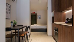 A compact hotel room with a kitchenette, a dining area, and a bed. - VLC HOST - Luz Casanova C (Valencia)