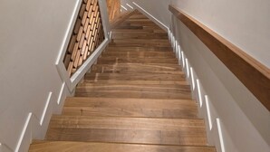 A wooden staircase with white railings and a small window at the top. - Kensington Area 10 Mins To Downtown! Clean and friendly! Temporary stays!  (Calgary)