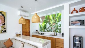 Une cuisine moderne dotée d’un plan de travail en marbre, de meubles en bois et d’un distributeur d’eau intégré.