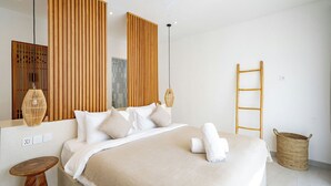 Une chambre moderne avec un grand lit, des panneaux en bois, une suspension lumineuse, une échelle en bois et un panier tressé.