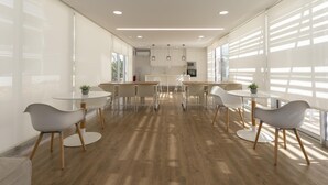 A modern, well-lit dining area with round tables and chairs, large windows, and a kitchen in the background. - Marina Real II, 2 bedrooms, by Bookindenia (Dénia)