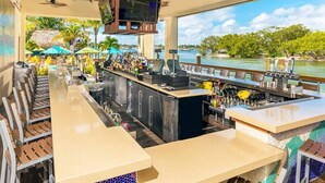 A bar area with a pool view, bar counters, and seating.