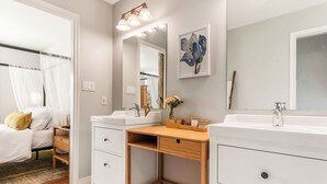 Een moderne badkamer met twee wasbakken, een houten wastafelmeubel en een grote spiegel.