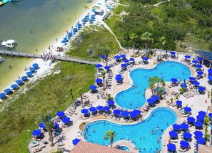A resort with multiple swimming pools, sun loungers, and umbrellas.