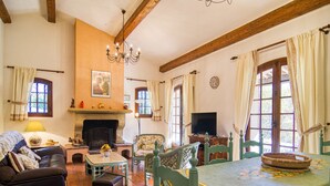 Un salon confortable avec une cheminée, un canapé, une table à manger avec des chaises et un téléviseur.