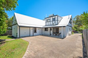 A modern two-story house with a garage, a covered patio, and a paved driveway. - Lakeside House Family Escape | Walk to Beach & Lake (Currimundi)