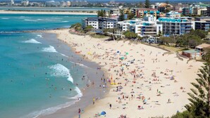 A beach with multiple buildings in the background. - Spinnaker Seas Ocean Views | Walk to Kings Beach | Pool (Kings Beach)