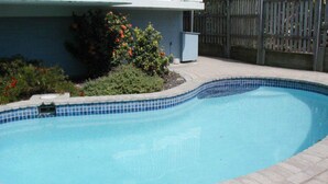 A swimming pool with a tiled edge, surrounded by a wooden fence and some greenery. - Spinnaker Seas Ocean Views | Walk to Kings Beach | Pool (Kings Beach)
