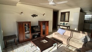 A living room with a sofa, coffee table, TV, and cabinets.