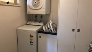 A compact laundry area with a washing machine, a dryer, and a stacked washer-dryer unit.