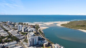 A coastal cityscape with beachfront properties, a marina, and a sandy beach. - Centrepoint 31 Ocean Views, Walk To Bulcock Beach (Caloundra)