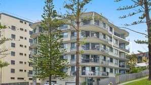 A multi-story residential building with balconies, a flat roof, and a gated entrance. - Campbells Cove U12 a Kings Beach Escape (Kings Beach)