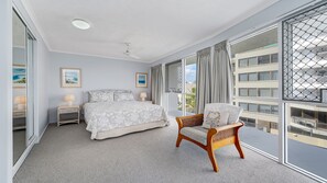 Une chambre d’hôtel avec un lit, une chaise, une table de chevet, une fenêtre avec des rideaux et une vue sur l’extérieur.