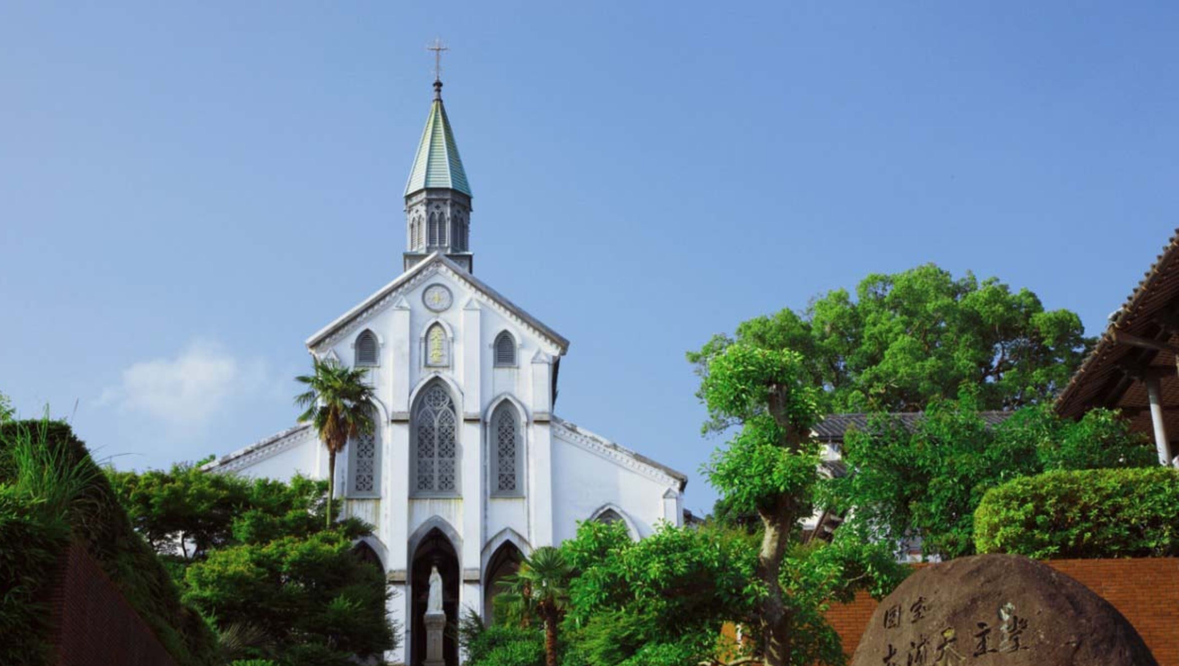 Una iglesia con un campanario alto y ventanas de arco.