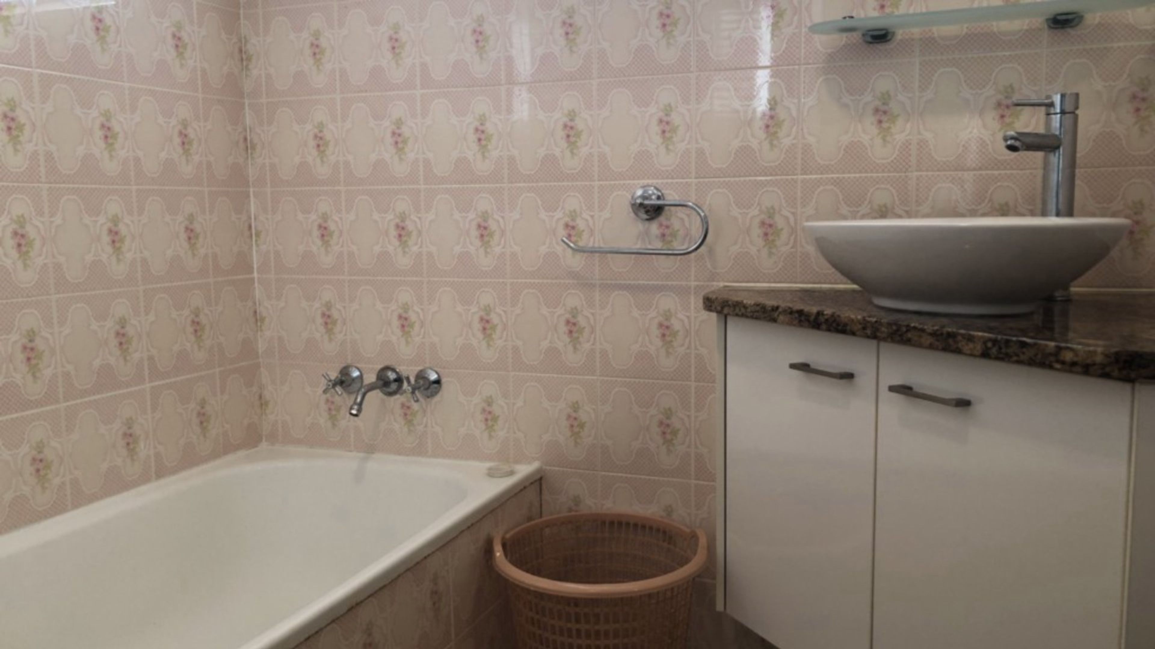 Ein Badezimmer mit einer Badewanne, einem Waschbecken und einem Wäschekorb.